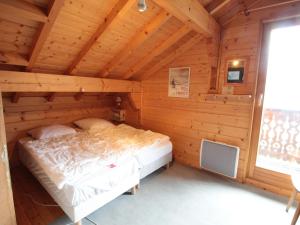 um quarto de um chalé de madeira com uma cama em Chalet Les Carroz d'Arâches, 4 pièces, 8 personnes - FR-1-572-243 em Les Carroz d'Arâches