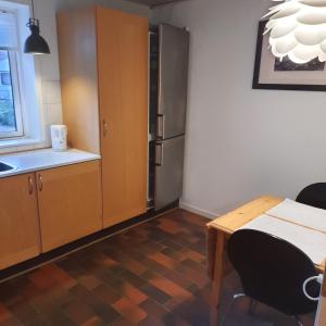 Habitación con cocina con mesa y nevera. en Agervej 45, Borris en Skjern