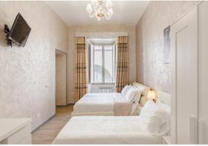 una camera da letto con due letti e un lampadario di Rome Place a Roma