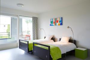 two beds in a room with a balcony at Hotel Middelpunt - Gratis Parking - Ontbijt inbegrepen! Nieuwjaarsbrunch 01 januari, op 31 december restaurant gesloten in Middelkerke