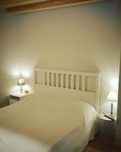 een slaapkamer met een wit bed en 2 lampen bij Pie Castello in Susegana