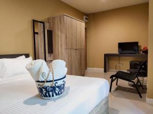 a hotel room with a bed with a basket of towels at The Lantern Suites in Ban Song Hong