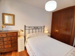 1 dormitorio con cama, tocador y espejo en Viveiro Histórico 3, en Viveiro