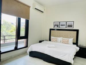 Una cama o camas en una habitación de BluO 2BHK Golf Course Road, Balcony, Lift, Parking
