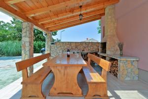 drewniany stół i ławki na patio w obiekcie Villa Valbandon 1719 w Fažanie