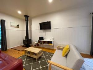 a living room with a couch and a wood stove at Tindoona Cottages in Foster