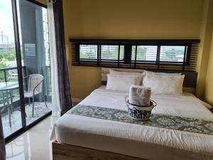 a bedroom with a large bed with a window at The Lantern Suites in Ban Song Hong