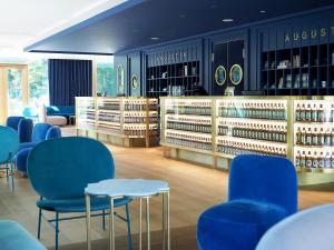 een winkel met blauwe stoelen en flessen wijn bij Jugend- und Familienhotel Augustin in München