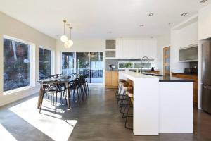 a kitchen and dining room with a table and chairs at Greystone - View - 4 King Beds - SPA - Pool Table - Fireplace in Les Éboulements