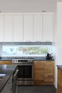 uma cozinha com armários brancos e uma janela em Greystone - View - 4 King Beds - SPA - Pool Table - Fireplace em Les Éboulements