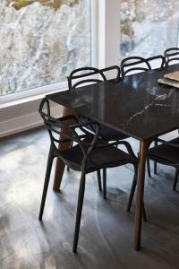 einem schwarzen Tisch und Stühlen vor einem Fenster in der Unterkunft Greystone - View - 4 King Beds - SPA - Pool Table - Fireplace in Les Éboulements