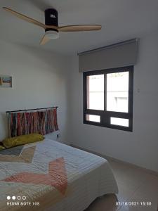 sypialnia z łóżkiem i wentylatorem sufitowym w obiekcie Apartamentos El Carmen w mieście Morro del Jable
