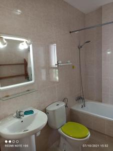 łazienka z toaletą, umywalką i wanną w obiekcie Apartamentos El Carmen w mieście Morro del Jable
