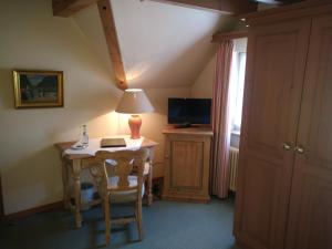 a room with a table with a lamp and a television at Landhotel Hirsch in Tübingen