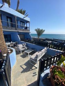 eine Terrasse des Resorts mit Stühlen und dem Meer im Hintergrund in der Unterkunft Bungalow Playa del Aguila in Maspalomas