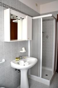 a bathroom with a white sink and a shower at 3MÙZEN apartments in Tremosine Sul Garda +77 photos