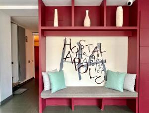 a red shelf with a bench with some pillows at Hostal Apolo in Barcelona