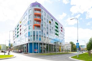 a tall white building with colorful windows on a street at Kadriorg Plaza 2 bedroom FREE Parking in Tallinn