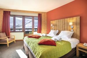 a hotel room with a bed with towels on it at Hôtel Les Menuires Les Bruyères in Les Menuires