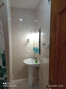 łazienka z umywalką i lustrem w obiekcie Apartamentos El Carmen w mieście Morro del Jable