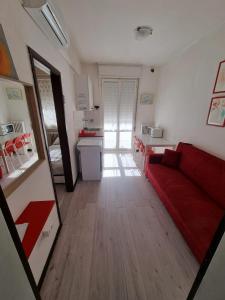 uma sala de estar com um sofá vermelho e uma cozinha em Appartamento Intero Bilocale Totalmente Arredato A Padova em Pádua
