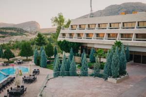 a building with a courtyard with a pool and trees at Ashur Hotel in Dokan