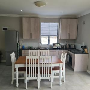 a kitchen with a wooden table and chairs and a kitchen with a refrigerator at Clarens Escape (Unit 2) in Clarens