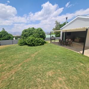 a house with a yard with chairs and a patio at Clarens Escape (Unit 2) in Clarens