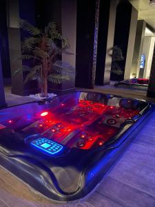 uma banheira de hidromassagem com luzes vermelhas num quarto em La suite Grenoble spa jacuzzi et sauna privatif em Grenoble