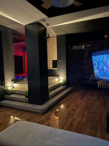 a living room with a tv and a wooden floor at La suite Grenoble spa jacuzzi et sauna privatif in Grenoble
