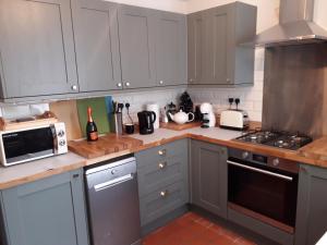 利物浦的住宿－Traditional House near Liverpool city centre，厨房配有灰色橱柜和炉灶烤箱