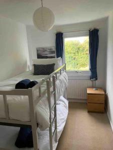 a bedroom with a bunk bed and a window at Cosy coastal home - 5 mins walk from the beach in Horton