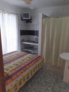 a bedroom with a bed and a tv on the wall at Obelix Apartment in Grand Baie