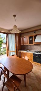 a kitchen with a wooden table with chairs and a dining room at Aria Fresca in Sovere