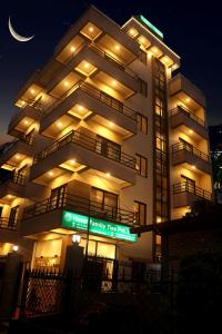un gran edificio con un cartel delante de él por la noche en Hotel Family Ties Pvt. Ltd., en Katmandú