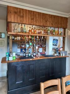 a bar with a lot of bottles of alcohol at The Tushielaw Inn in Selkirk