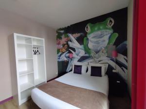 a bedroom with a bed with a painting of a frog on the wall at The Originals Boutique, Hôtel de l'Univers, Montluçon in Montluçon