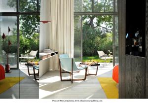 a living room with a table and chairs and windows at Sezz Saint-Tropez in Saint-Tropez