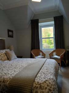 una camera con un grande letto e una finestra di The Tushielaw Inn a Selkirk