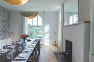 a dining room with a long table in a room with a fireplace at So'House Manor in Spa