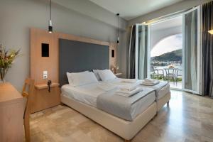 a bedroom with a large bed and a large window at Hotel Punta in Punta