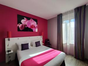 a bedroom with a large bed with a pink wall at The Originals Boutique, Hôtel de l'Univers, Montluçon in Montluçon +47 photos