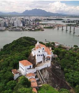 a white building on top of a hill with a city at INCRIVEL FLAT106 PASSARGADA VISTA p MAR in Vila Velha