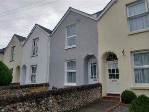 a row of white houses with a stone wall at ChiPad Duo - Comfy house with garden & parking in Chichester