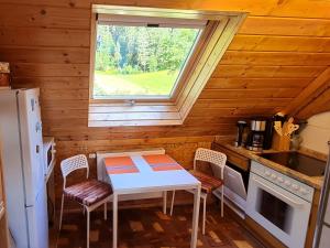 een keuken met een tafel en een raam in een huisje bij Ferienwohnung am Wald in Baiersbronn