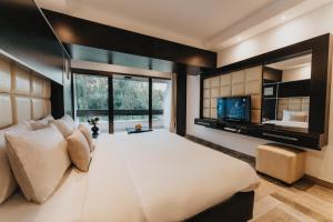 a bedroom with a large bed and a television at Ashur Hotel in Dokan