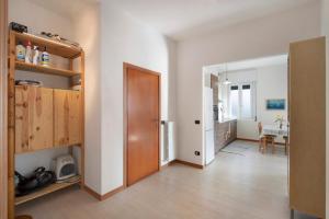 a room with a hallway with a door and a kitchen at Sibi Apartment in Lierna
