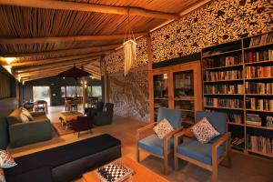a living room with a couch and chairs and bookshelves at The Indus River Camp in Leh