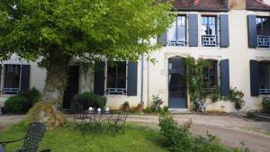 a house with a tree and chairs in the yard at Clos Terre-lune in Nuits-Saint-Georges