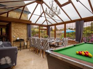a room with a pool table in a conservatory at Kingfisher Cottage in Winchcombe